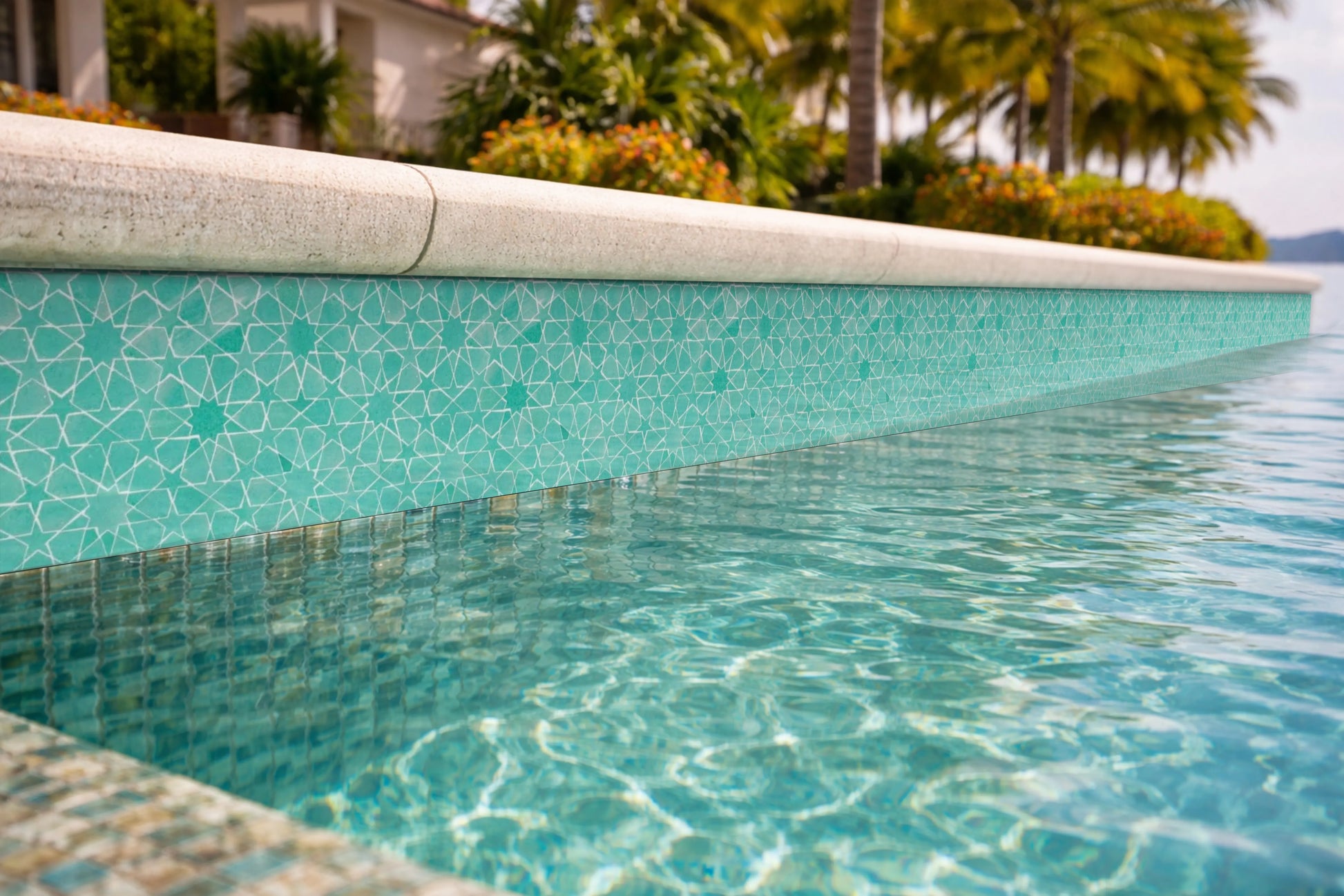Premium green mosaic waterline tiles for luxury pool design with clear blue water contrast